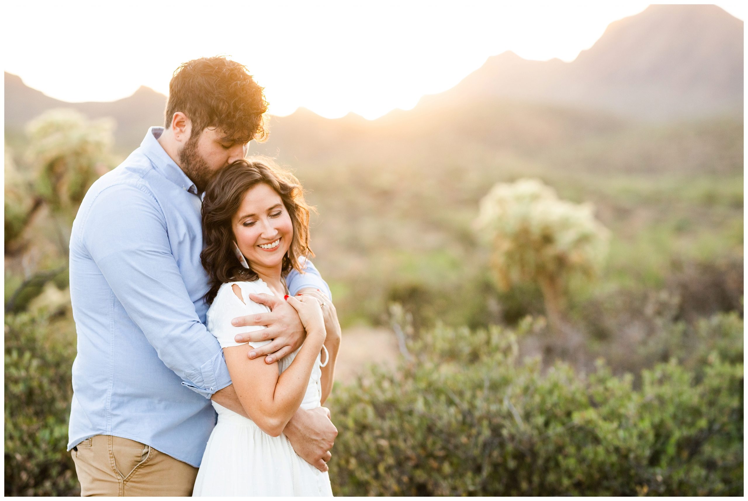 Desert scenery with engaged couple snuggling